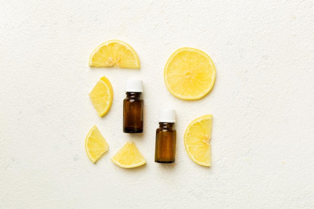 Bottiglie con olio essenziale di frutta al limone su sfondo di legno medicina alternativa vista dall'alto con spazio per la copia