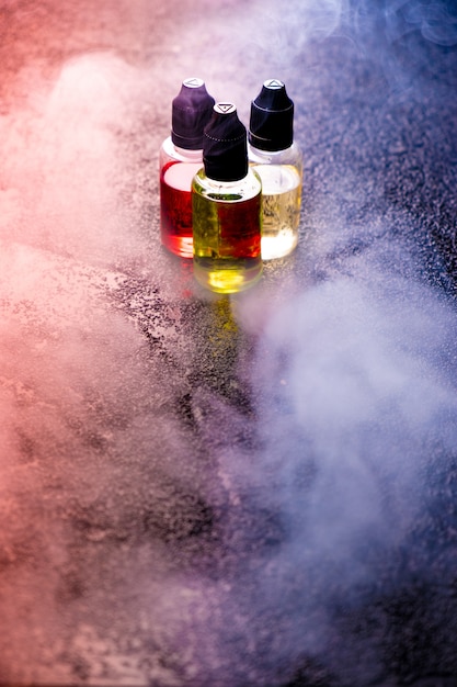 Bottiglie del liquido delle nuvole di fumo di concetto di Vape