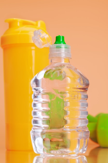 Bottiglie di acqua in plastica su uno sfondo beige pastello