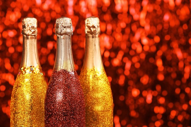 Bottiglie di champagne decorate su sfondo sfocato scintillante luminoso
