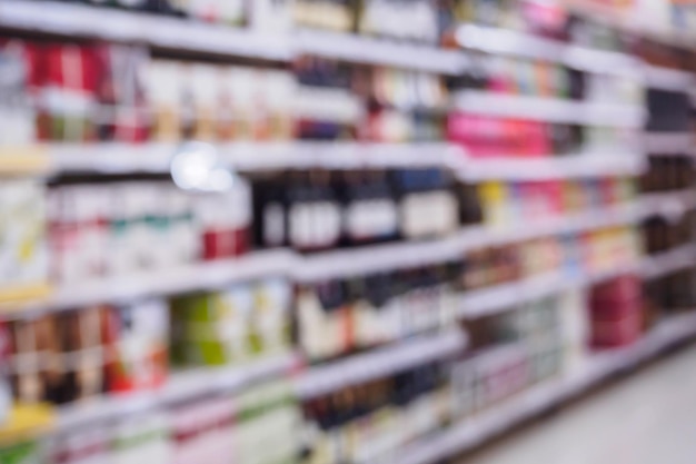 Bottiglie di liquori di vino e scaffali per bevande alcoliche in supermercato o negozio di liquori sfocato sfondo sfocato