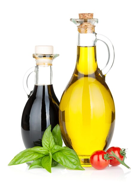 Bottiglie di olio d'oliva e aceto con basilico e pomodori