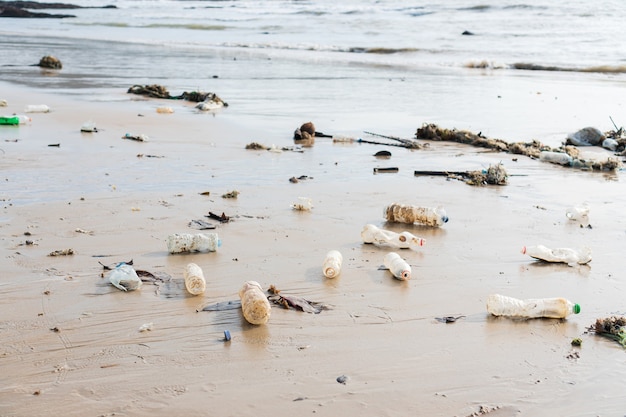 Bottiglie di plastica e altri rifiuti abbandonati sulla spiaggia. Inquinamento ambientale, concetto di problema ecologico.