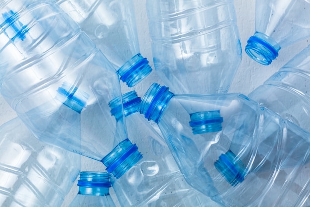 Bottiglie di plastica su sfondo blu come simbolo di catastrofi ecologiche