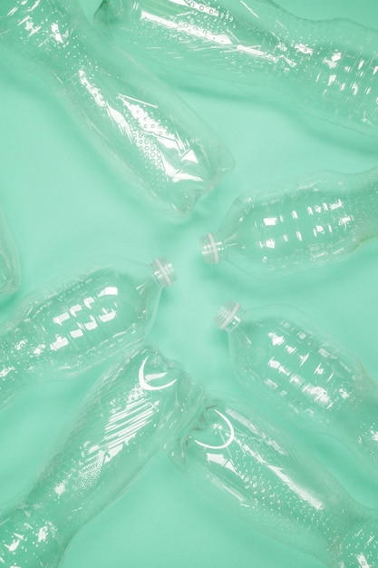 Bottiglie di plastica vuote dell'animale domestico del modello dell'acqua su fondo verde