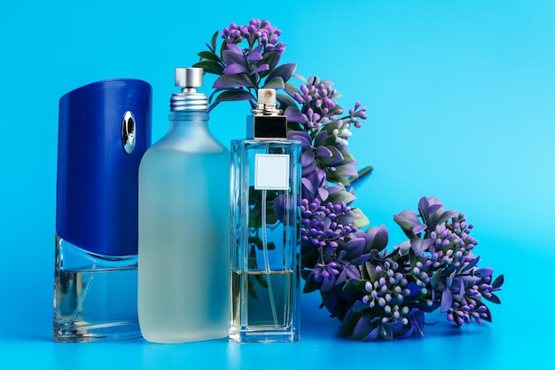 Bottiglie di profumo con fiori su azzurro