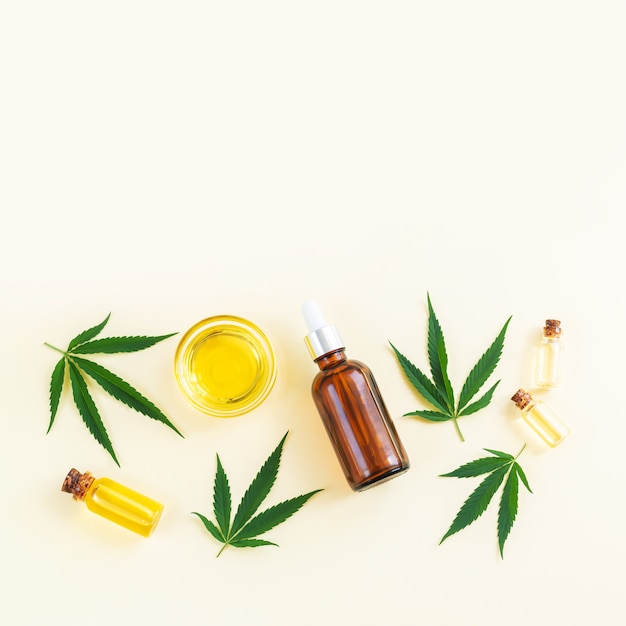 Bottiglie di vetro cannabis cbd oil thc tintura e foglie di canapa