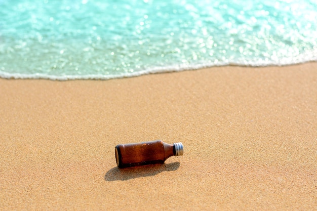 Bottiglie di vetro sulla spiaggia e sullo sfondo blu del mare