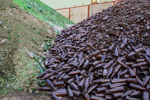 Bottiglie marroni di pile di vetro nella fabbrica dell'industria del riciclaggio