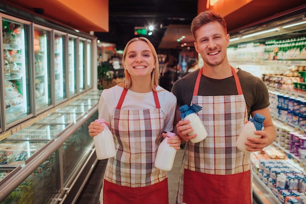 Bottiglie per il latte della tenuta della donna e del giovane