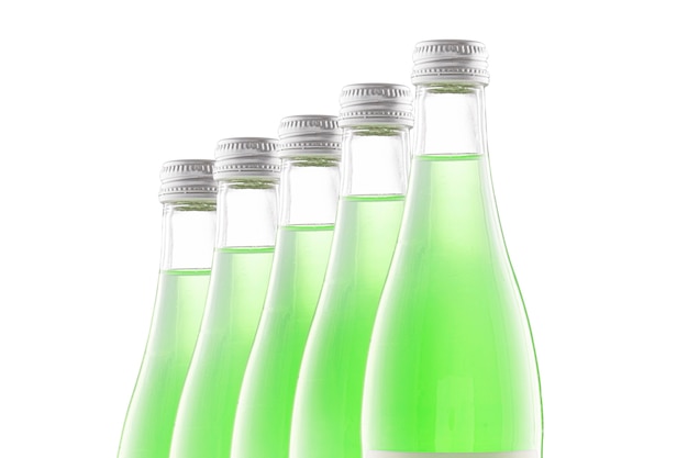 Bottiglie trasparenti di limonata verde stanno in fila una dietro l'altra.