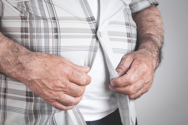 Bottoni di fissaggio uomo grasso sulla camicia.