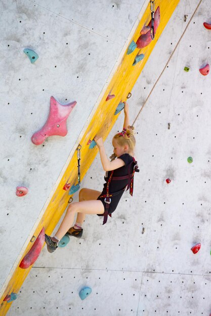 Bouldering, bambina che si arrampica sul muro