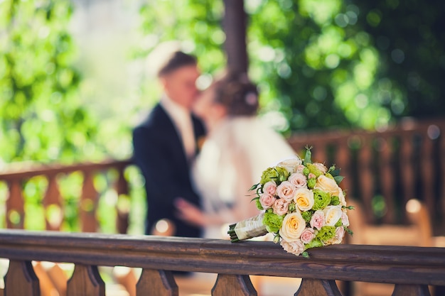 Bouquet da sposa bella sullo sfondo di baciare la sposa e lo sposo