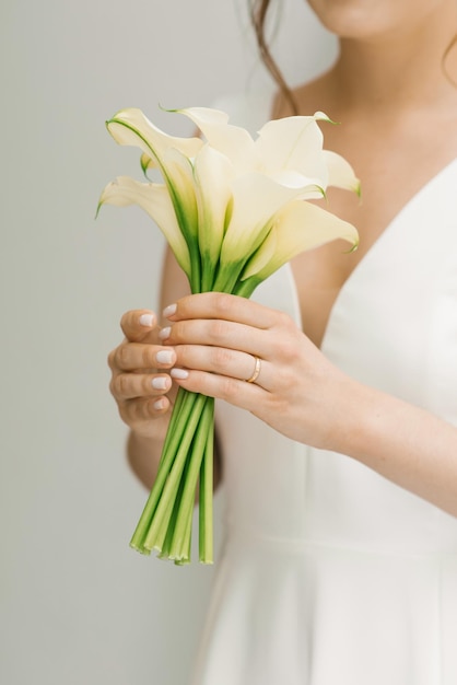 Bouquet da sposa bianco di calle nelle mani della sposa