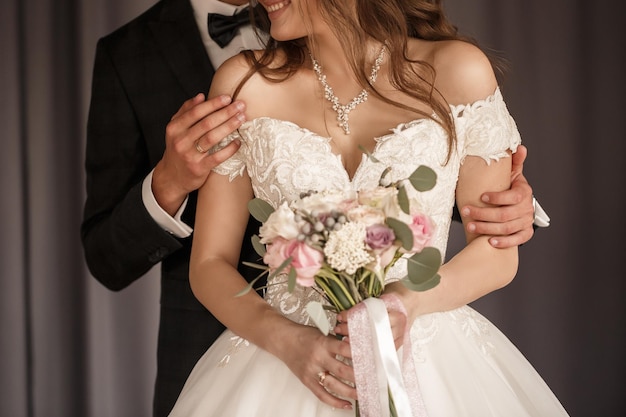 Bouquet da sposa con fiori naturali freschi nelle mani della sposa