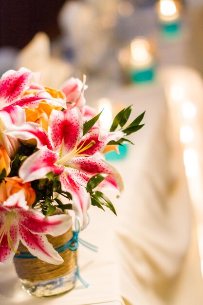 Bouquet da sposa con gigli rosa e rose arancioni.