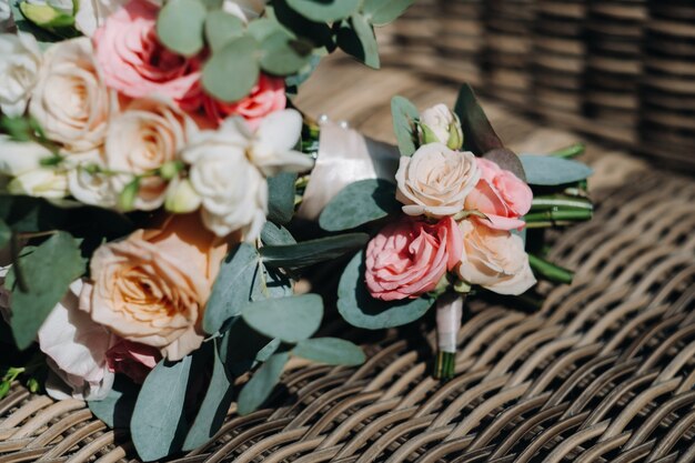 Bouquet da sposa con peonie e rose su una sedia e boutonniere.L'arredamento al matrimonio