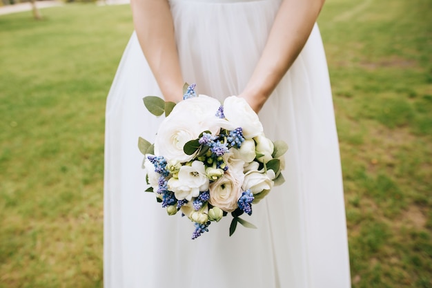 Bouquet da sposa di belle peonie bianche nelle mani della sposa