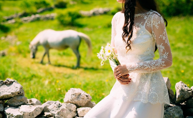 Bouquet da sposa di margherite nelle mani della sposa