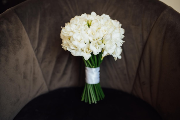 Bouquet da sposa di peonie sdraiato sulla sedia