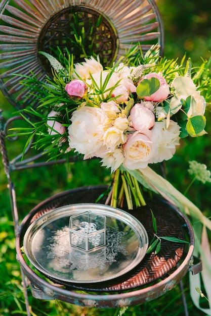 Bouquet da sposa di peonie su una sedia vintage in metallo matrimonio a m