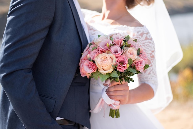 Bouquet da sposa di rose nelle mani della floristica degli sposi per la vacanza