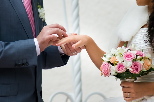 Bouquet da sposa e mani con anelli