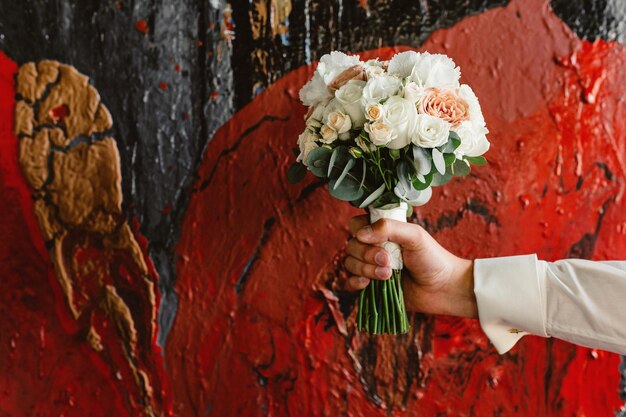 Bouquet da sposa in mano su uno sfondo artistico unico Dipingere pitture Regalo alla sposa