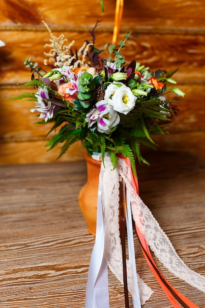 Bouquet da sposa luminoso con nastri in un vaso