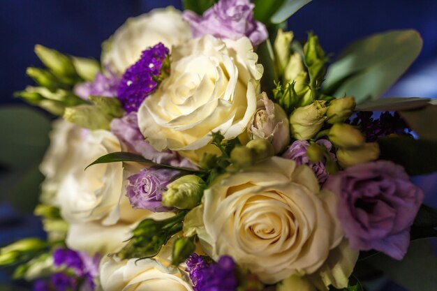 Bouquet da sposa luminoso di rose viola bianche estive con fedi nuziali