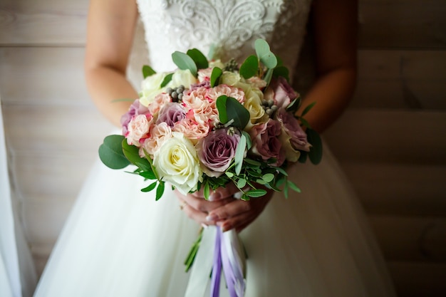 Bouquet da sposa nelle mani degli sposini