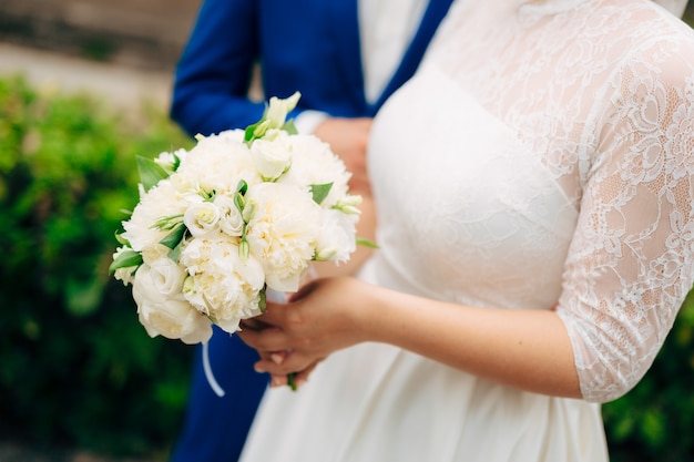 Bouquet da sposa nelle mani della sposa alla cerimonia