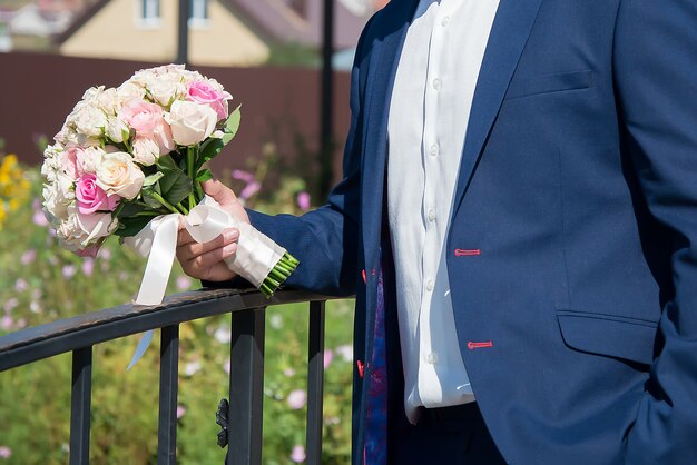 Bouquet da sposa nelle mani dello sposo