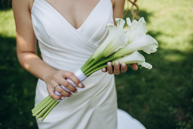 Bouquet da sposa nelle sue mani Bellissimo bouquet da sposa nelle mani di una sposa Messa a fuoco selettiva Giovane sposa che tiene il bouquet da sposa con fiori rosa e bianchi in primo piano