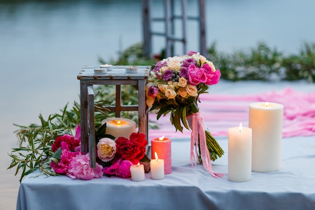 Bouquet da sposa tra decorazione con candele e fiori freschi
