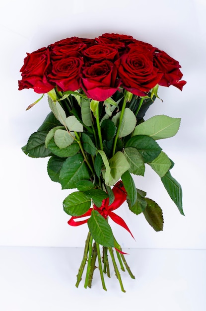 Bouquet di bellissime rose legate con nastro rosso. Foto dello studio.