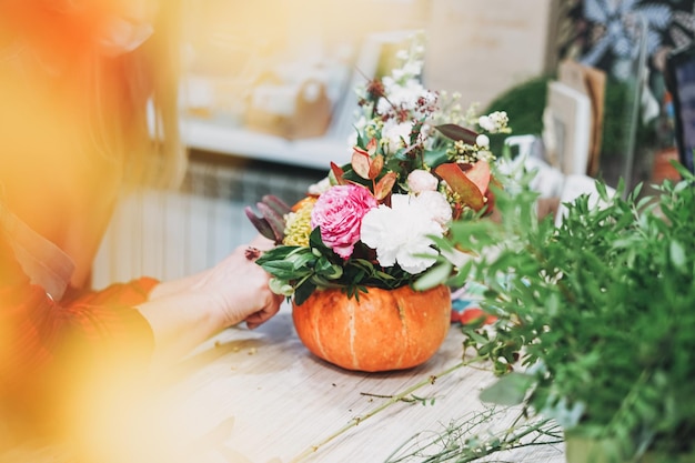 Bouquet di composizioni floreali autunnali fai-da-te in fiorista di zucca presso lo studio di floristry di lavoro