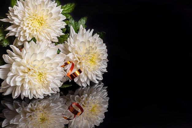 Bouquet di crisantemo bianco su sfondo scuro con riflessione Regalo di festa