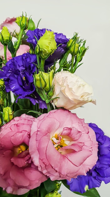 Bouquet di eustoma multicolore Rosa e lilla con fiori bianchi su fondo chiaro