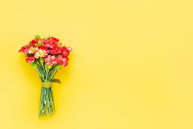 Bouquet di fiori di garofano rosso su giallo