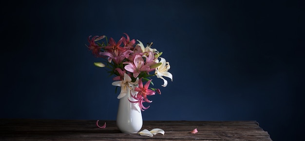 Bouquet di fiori di giglio in vaso su sfondo scuro