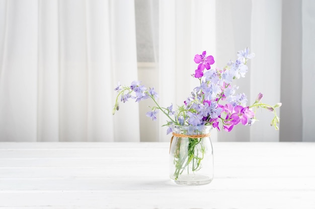 Bouquet di fiori di lupino viola in un tavolo di vaso di vetro