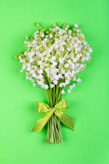 Bouquet di fiori di mughetto con fiocco verde su verde