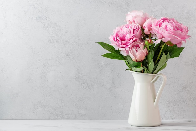 Bouquet di fiori di peonia rosa in vaso su sfondo bianco con spazio per la copia Still life Festa della donna o concetto di matrimonio