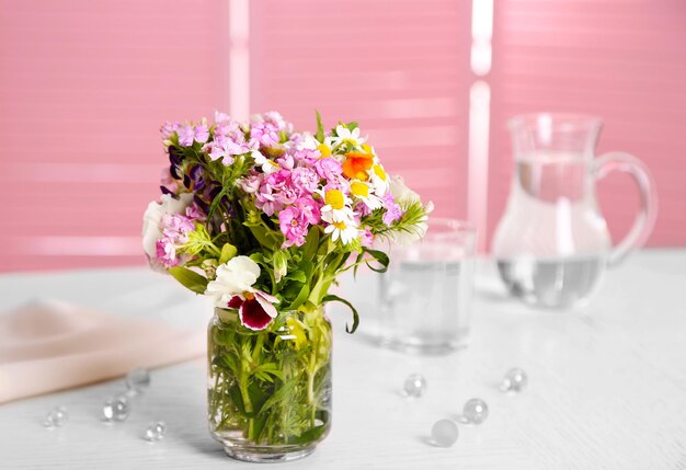 Bouquet di fiori di prato in vaso di vetro sul tavolo