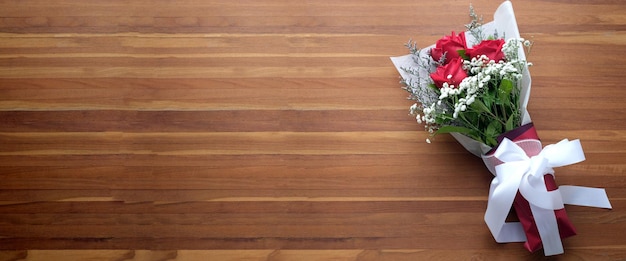 Bouquet di fiori di rose rosse su fondo di legno