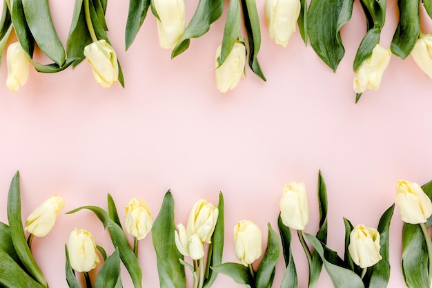 Bouquet di fiori di tulipano pastello e giallo su sfondo rosa piatto laico vista dall'alto sfondo San Valentino