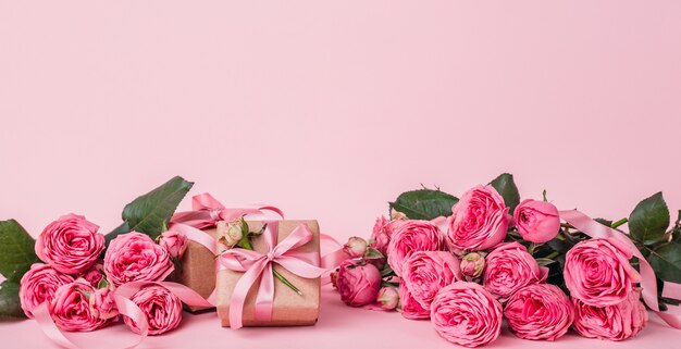 bouquet di fiori e scatole regalo isolati sul rosa