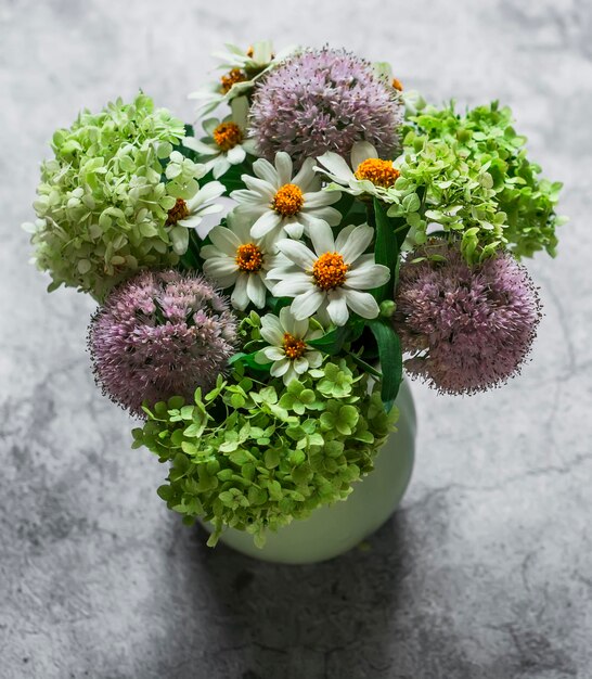 Bouquet di fiori estivi di margherite di ortensie su sfondo grigio una vista sopra lo spazio della copia